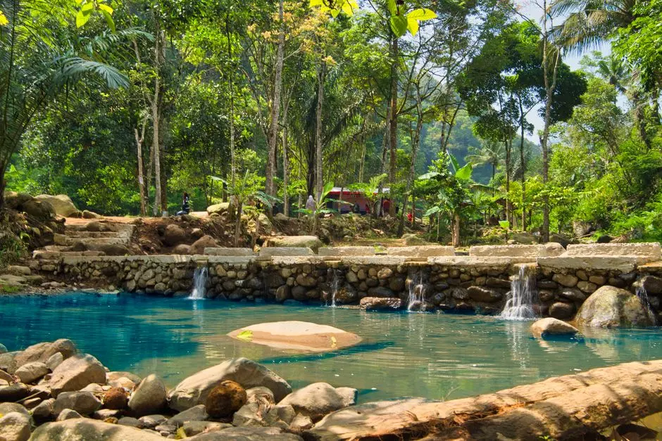 Suasana air terjun Curug Cimarinjung dengan kolam alami hijau toska